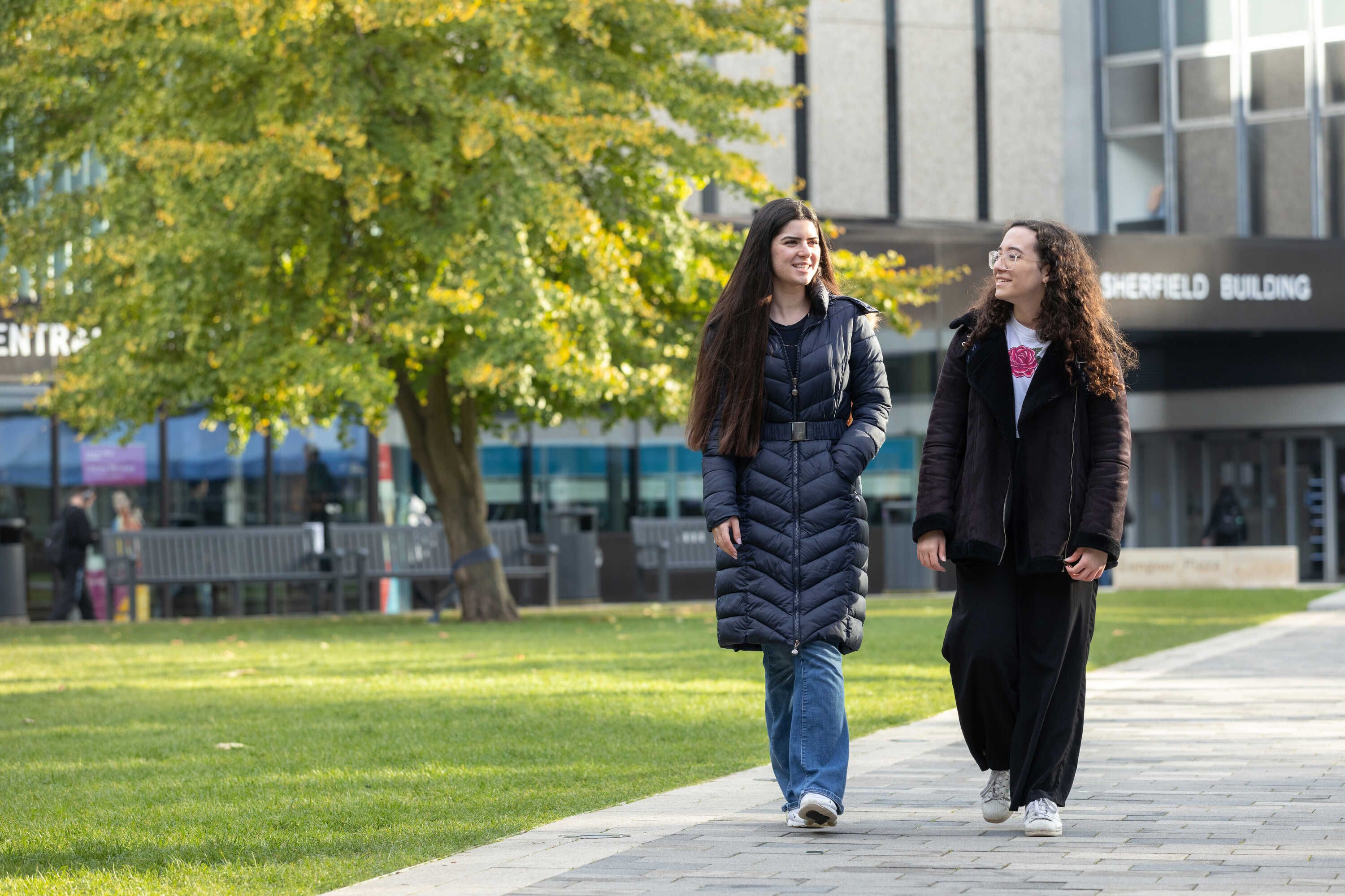Two students walking across campus