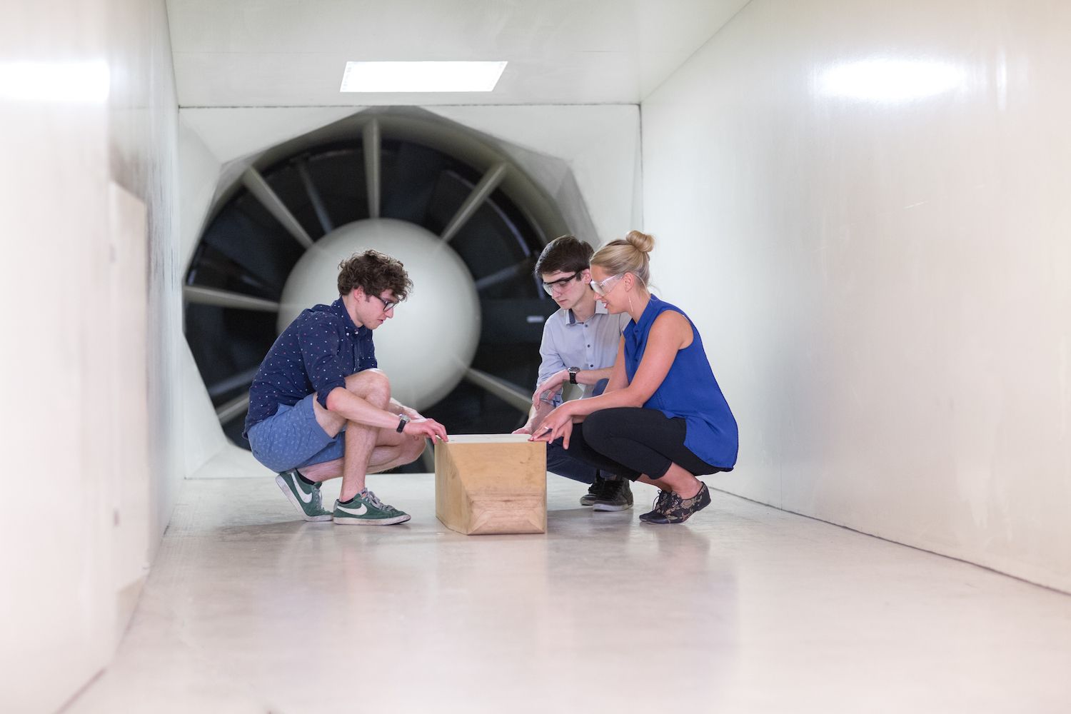 Students in wind tunnel with large turbine.