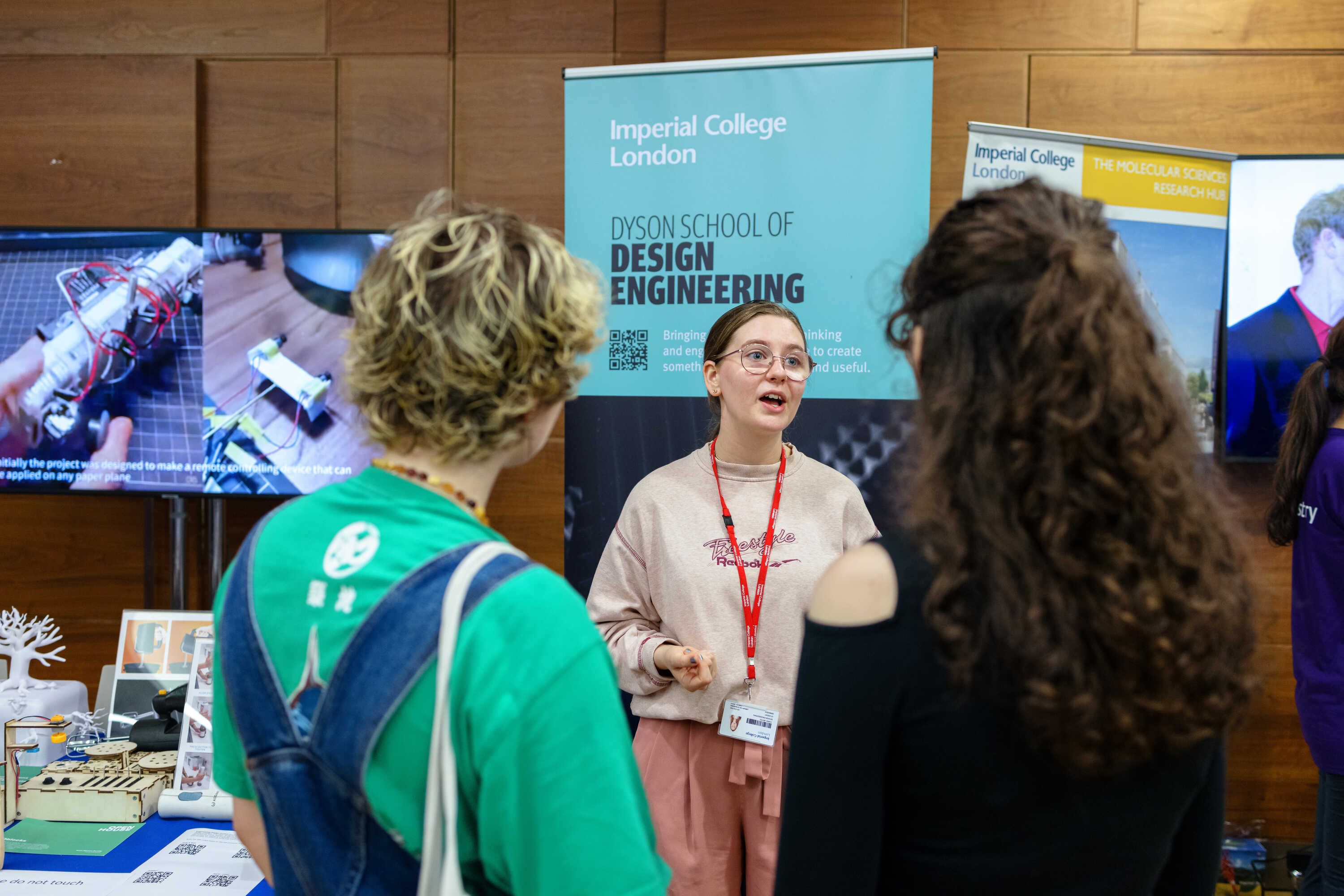 A student from the Dyson School of Design Engineering talking to Open Day visitors