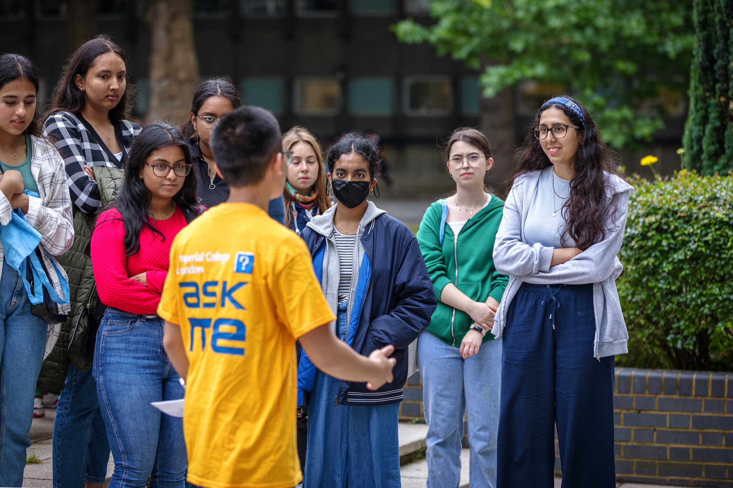 A student volunteer at the Open Day speaking to a group of visitors