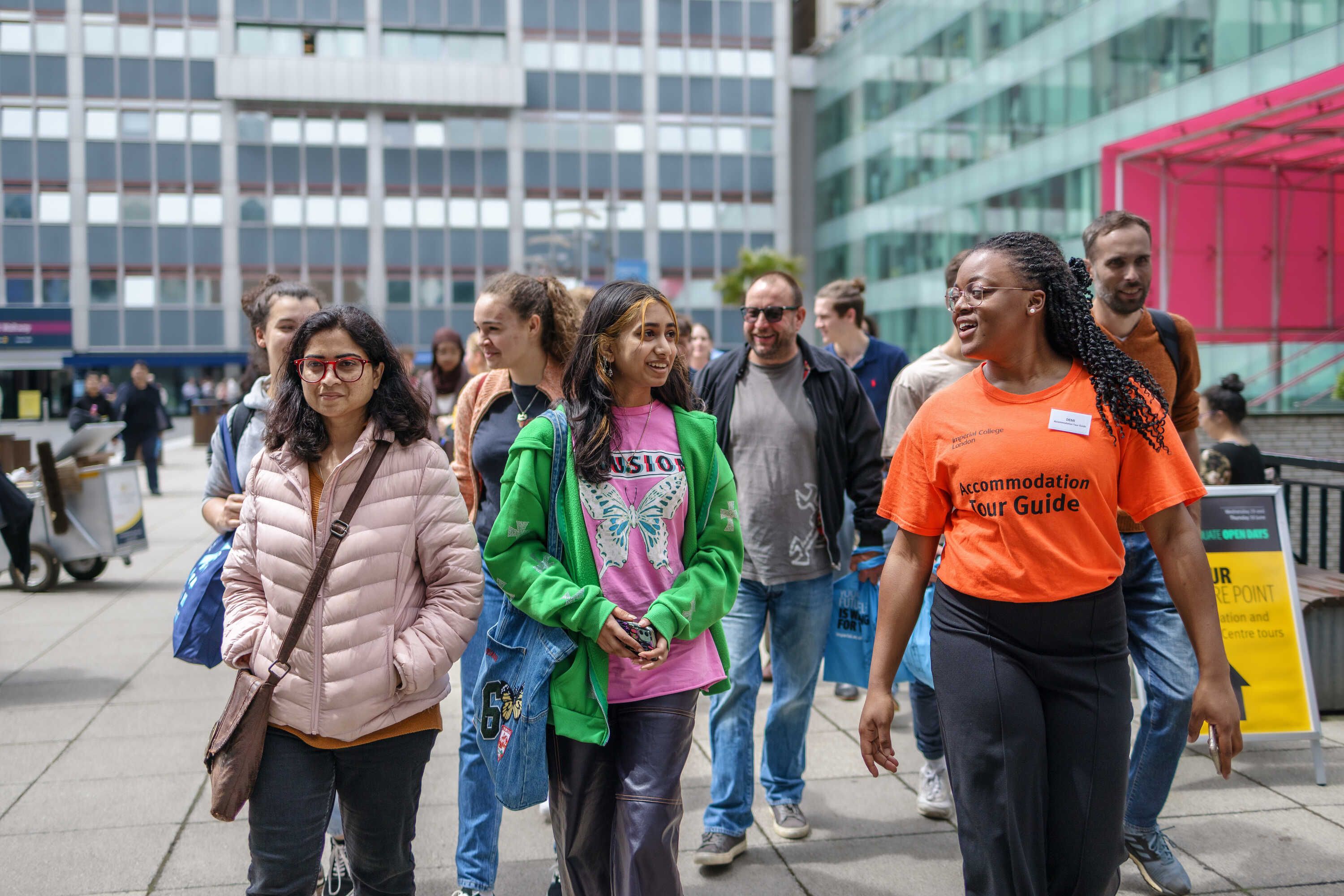 A student leading a group of visitors to campus