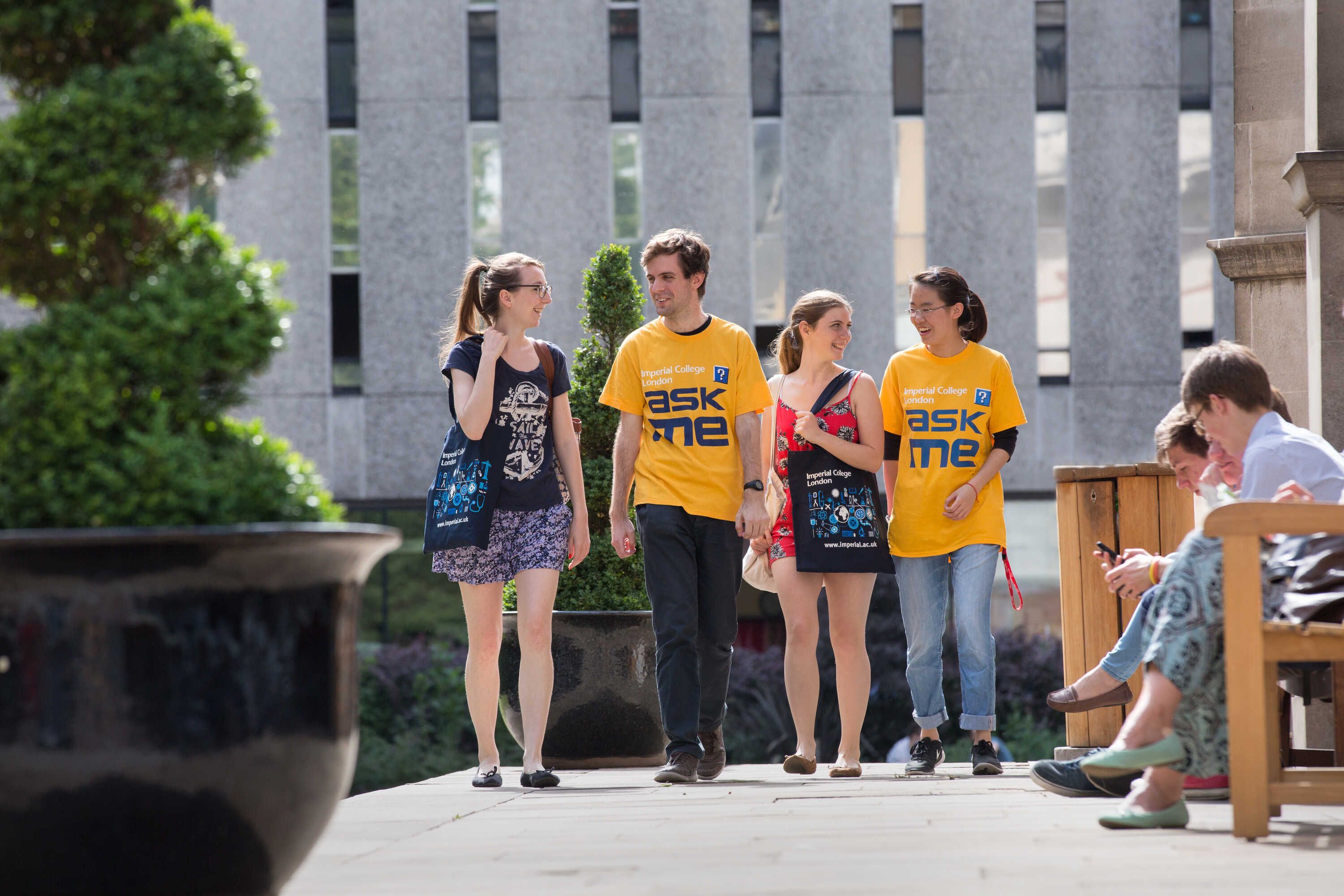 Two Open Day volunteers walking across campus with two Open Day visitors