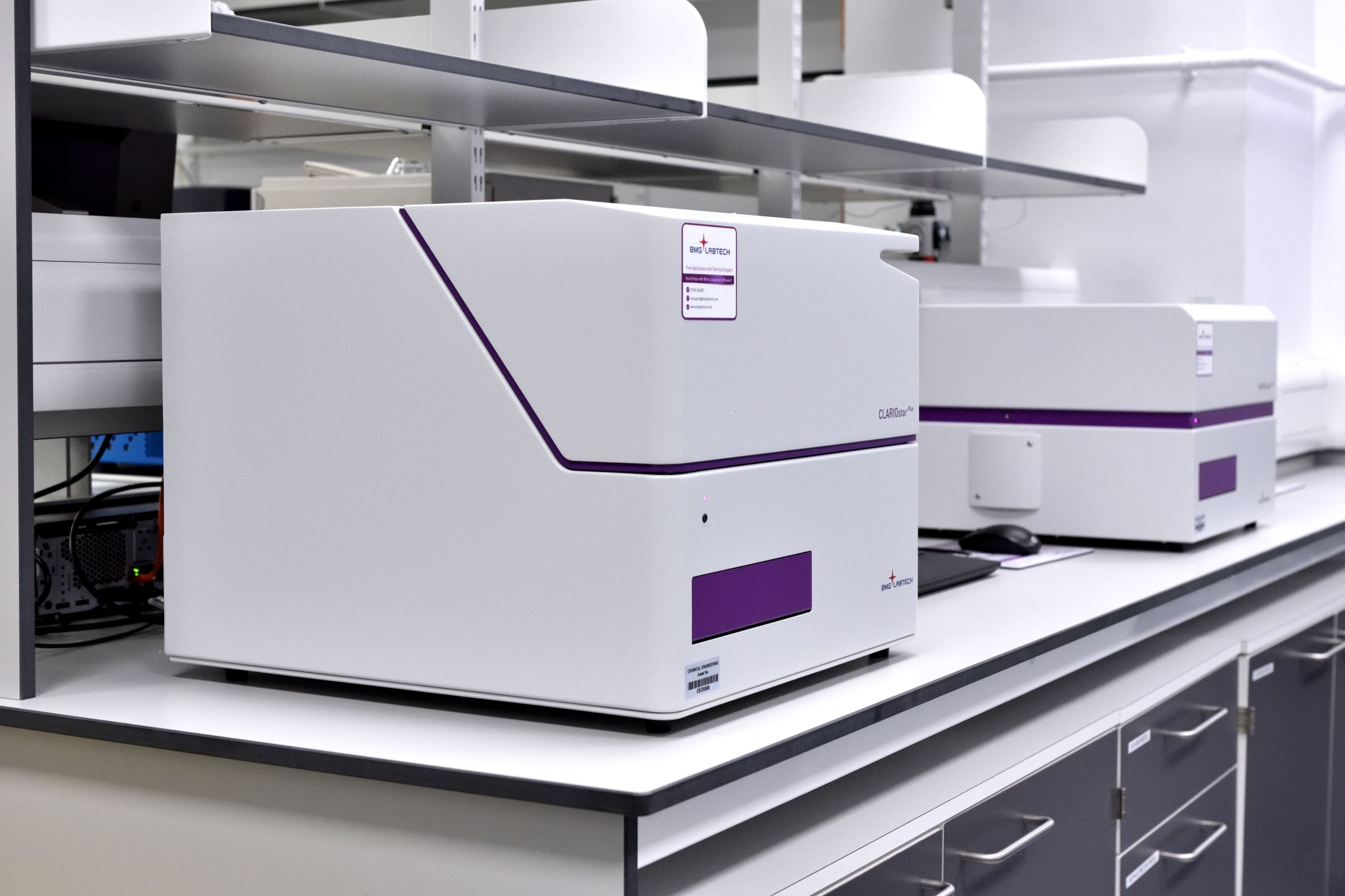 A photograph of two plate reader instruments supplied by BMG Labtech. One is a UV-vis photo-spectrometer and the other is a nephelometer