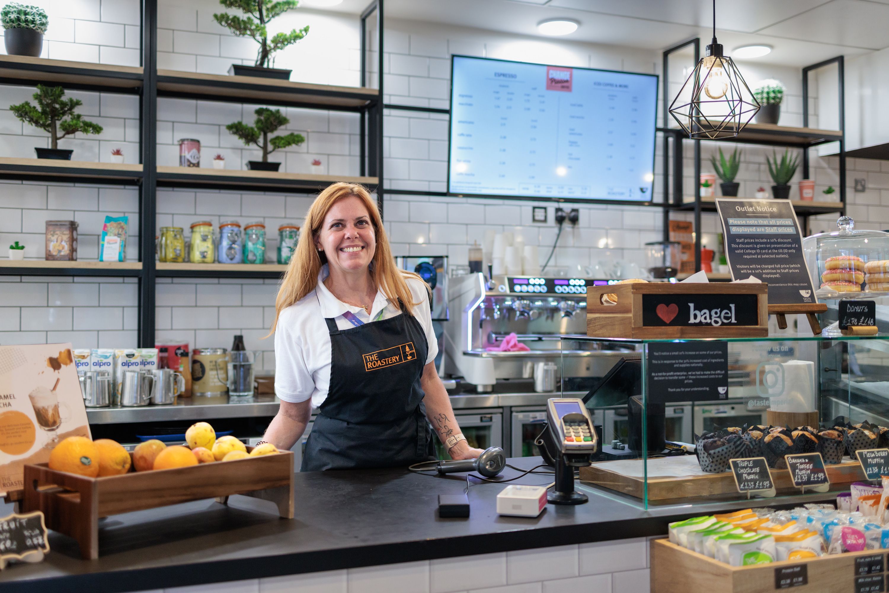 Member of Imperial catering staff Michelle Leandro Pontes Costa smiling behind the counter in an Imperial café