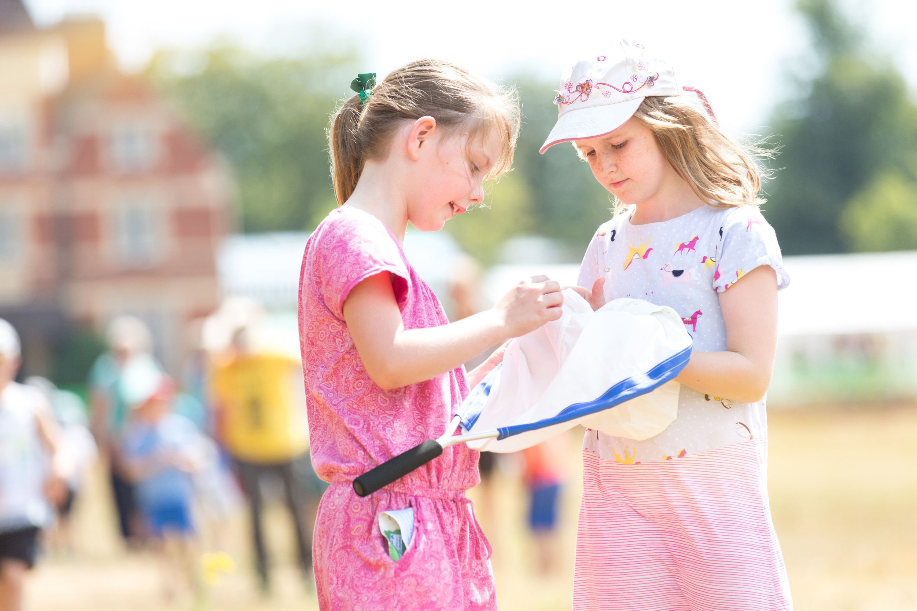 Two young girls examining the contents of a butterfly net