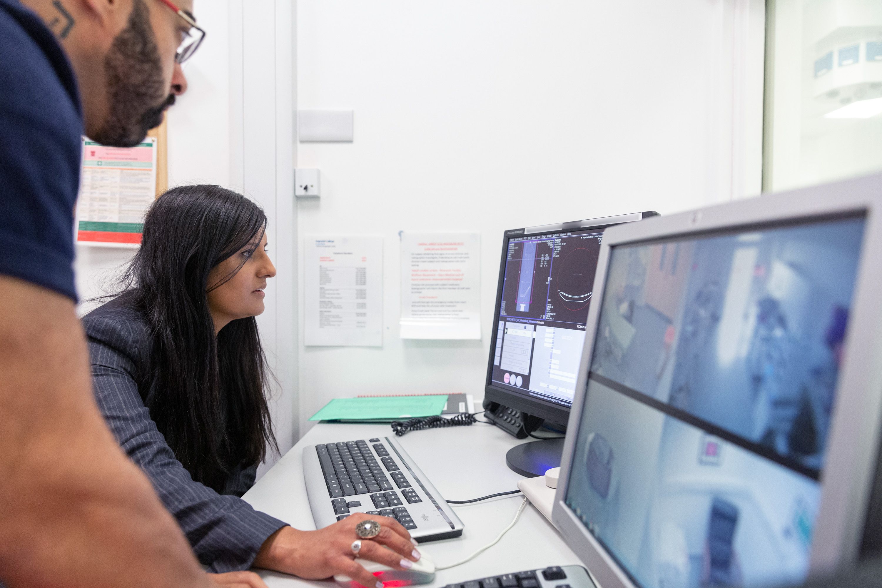 Two people looking at computer screens in a laboratory