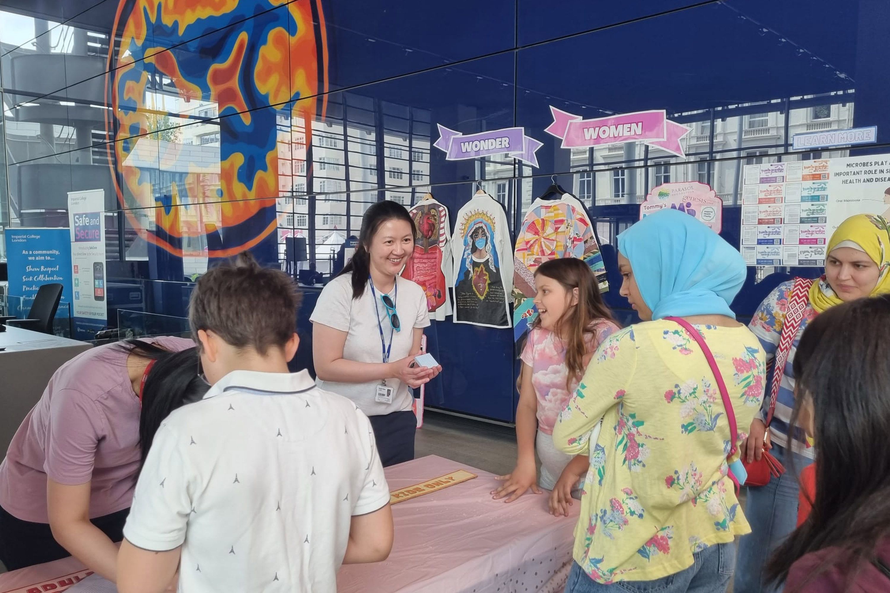 A picture of Doctor Sherrianne Ng discussing her research with members of the public