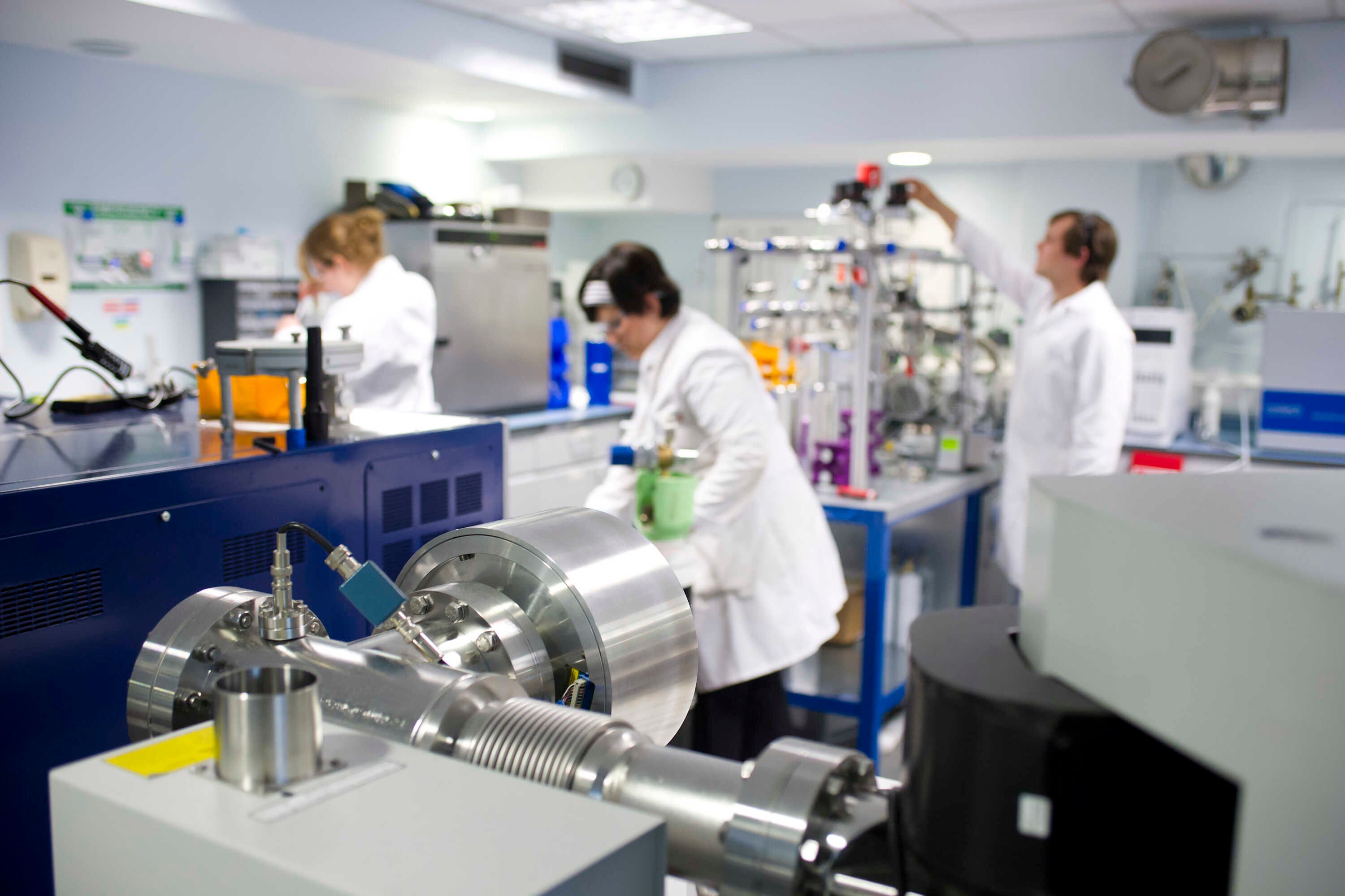 Flight tube and collector array of the MAT 253 stable isotope mass spectrometer. In the background, Ms Anna Joy Drury, Dr Anne-Lise Jourdan and Dr Cédric John