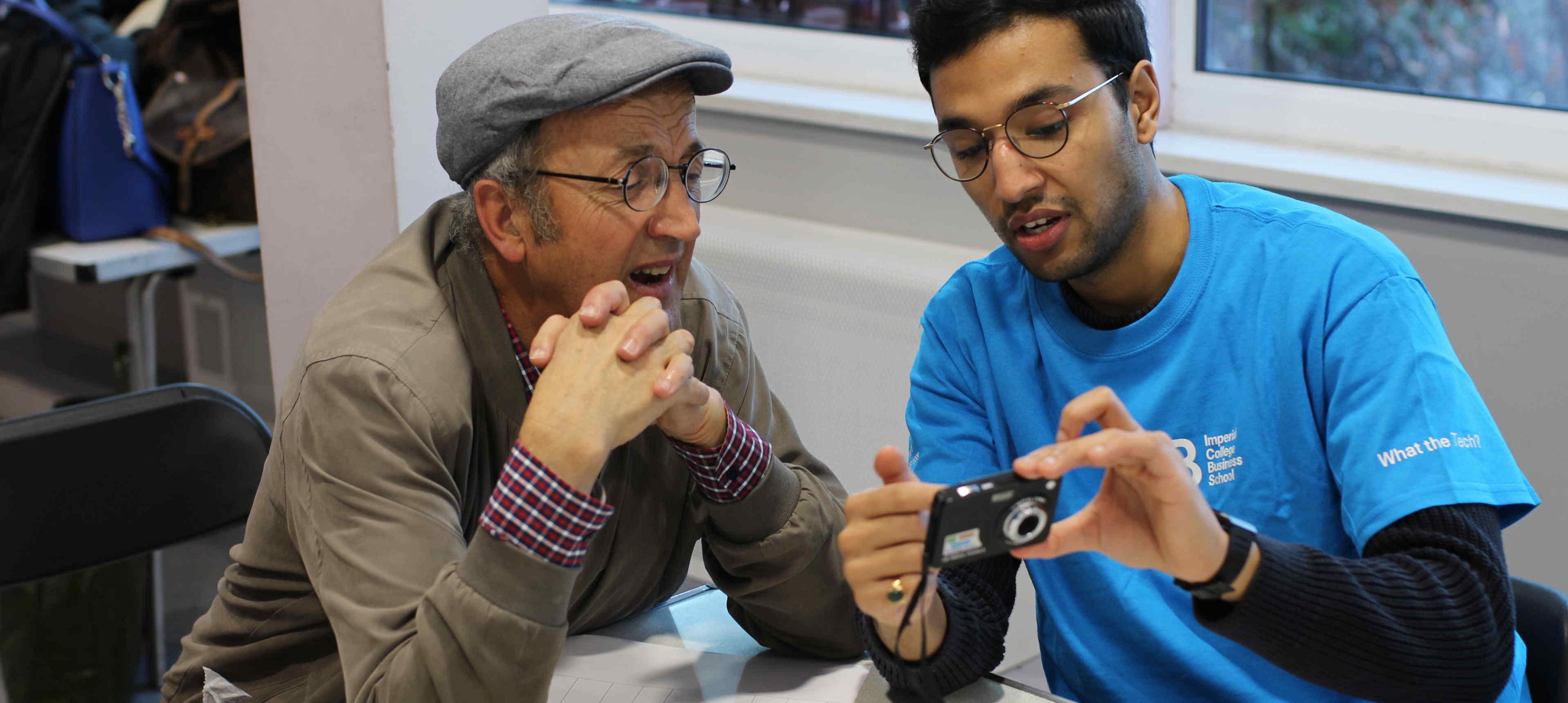 An Imperial staff member showing a local resident how to use their camera at What the Tech