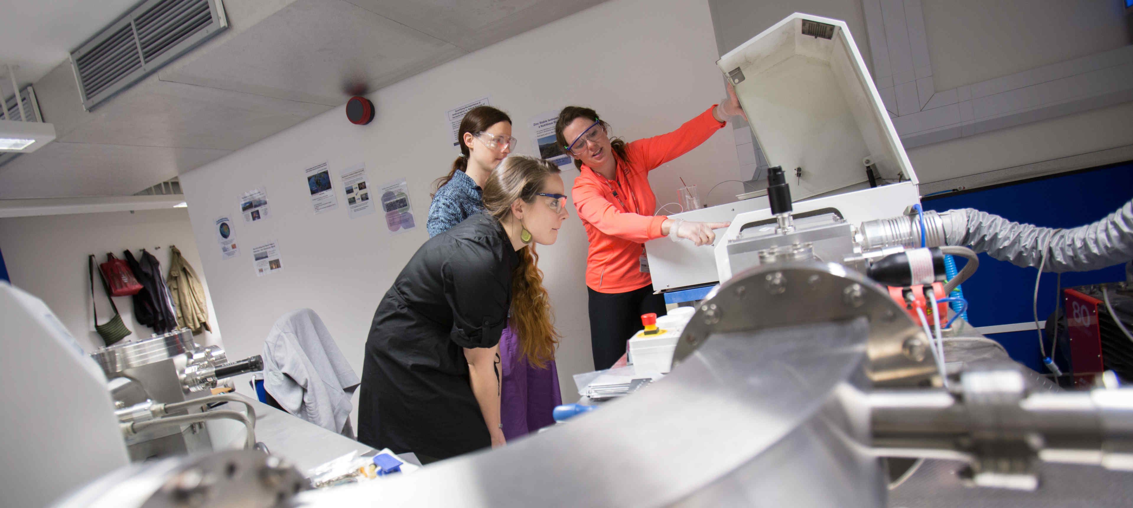 PhD students looking at equipment