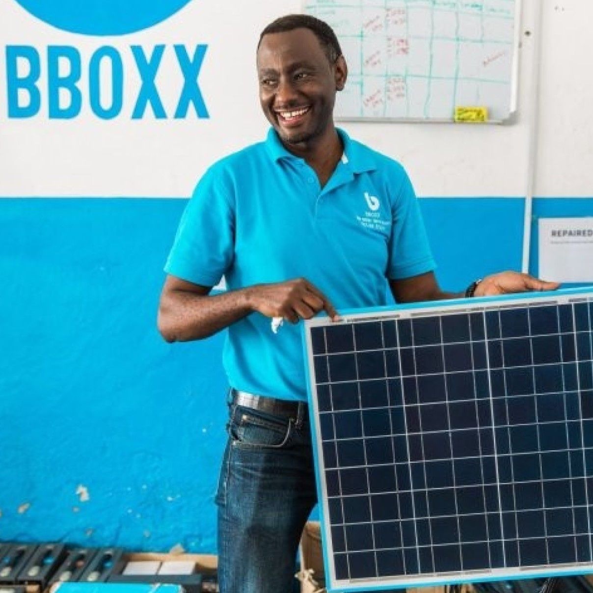 A member of the Bboxx team with a solar panel