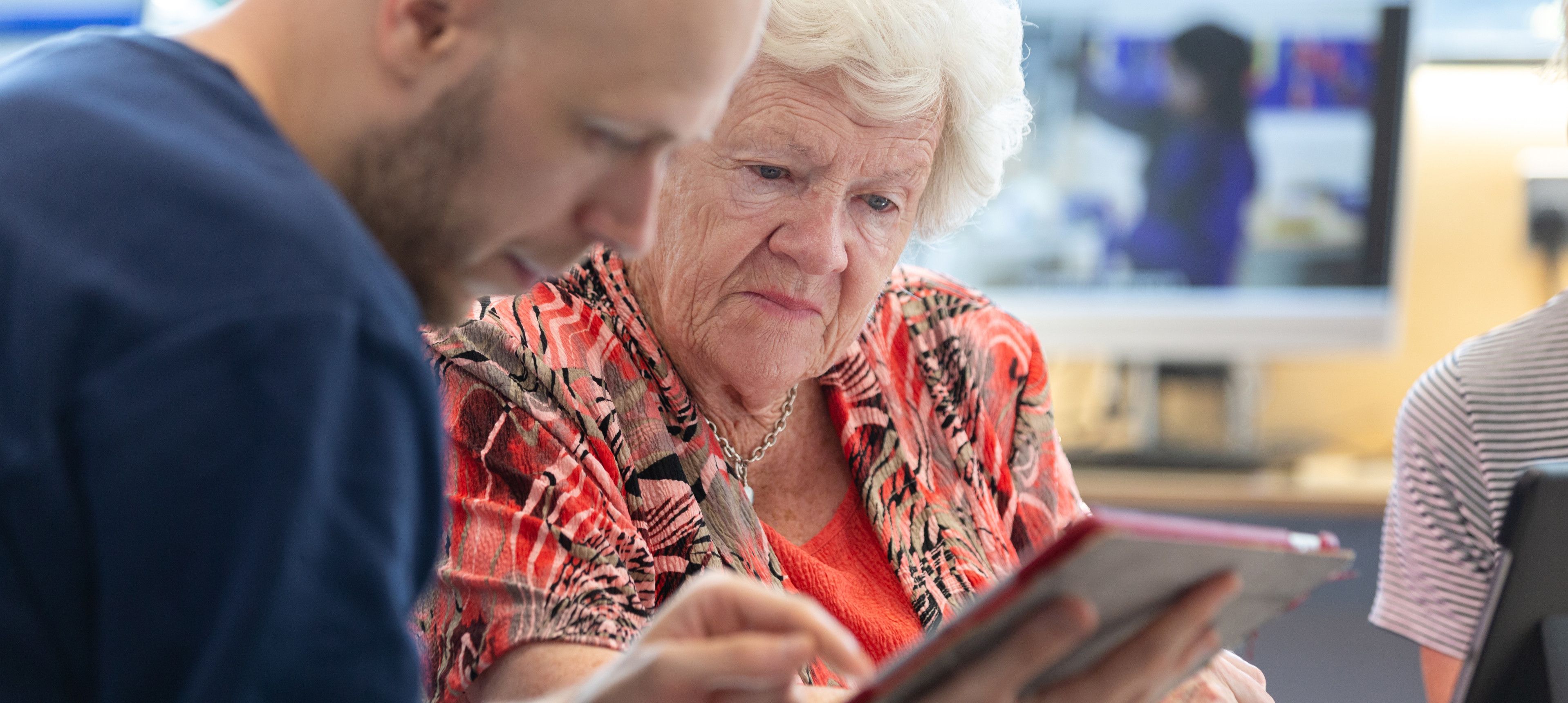 Elderly person being helped with technology