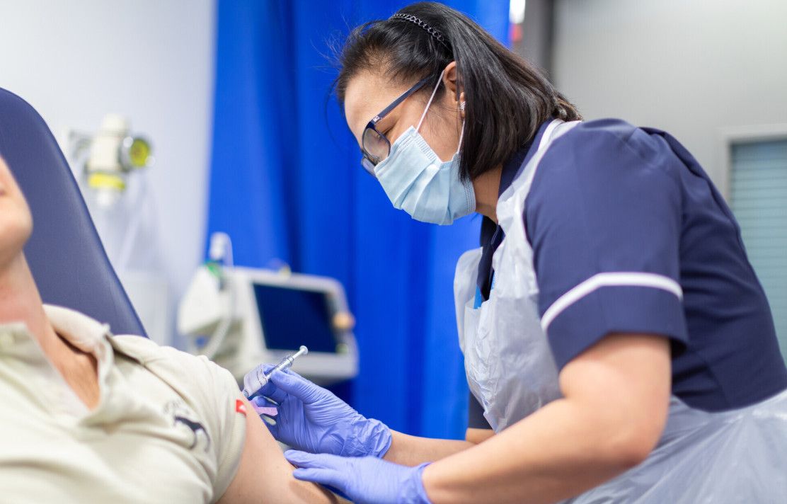 A clinical researcher administering a vaccine as part of the Oxford vaccine trial