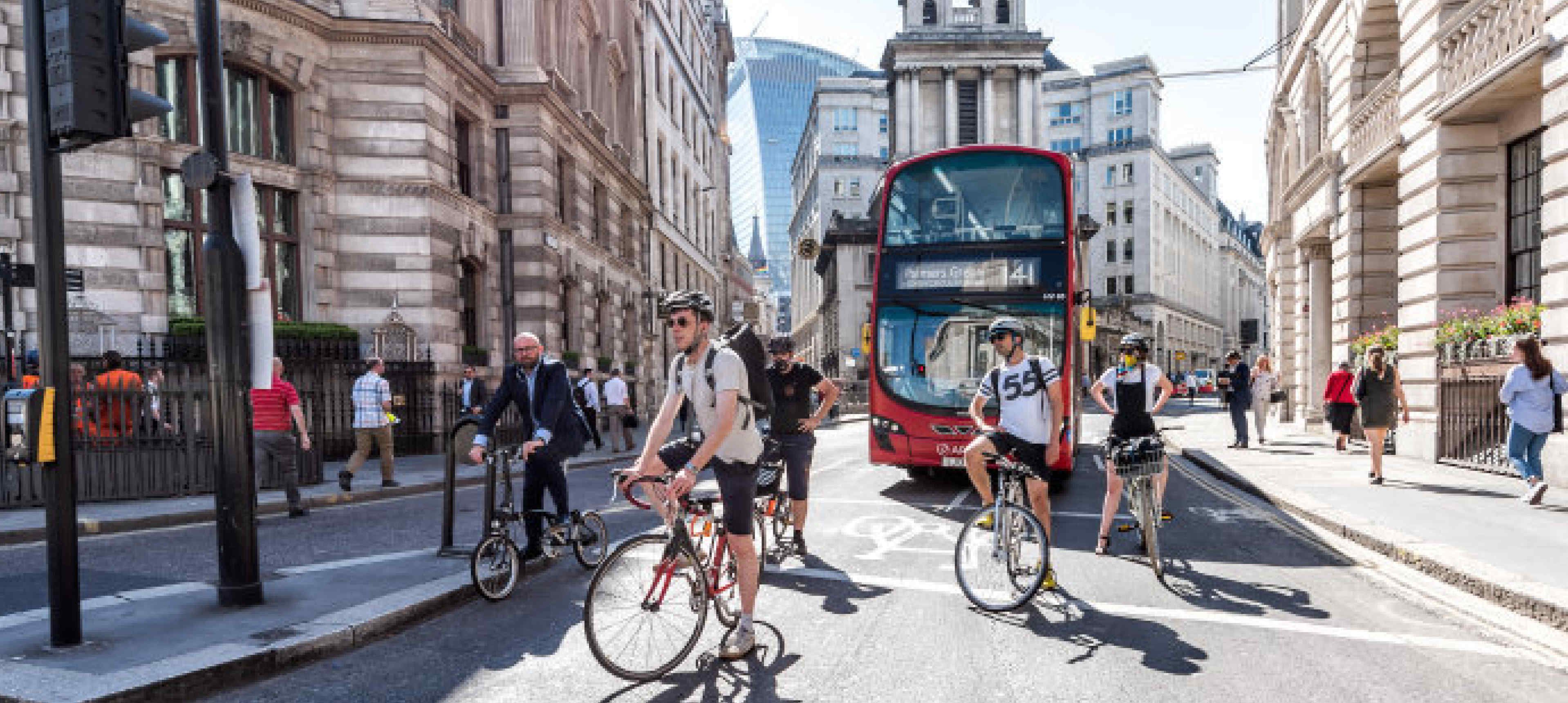 Cyclists in London in front of a double decker