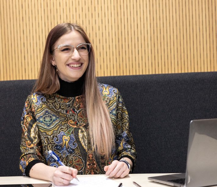 A student smiling at her desk.