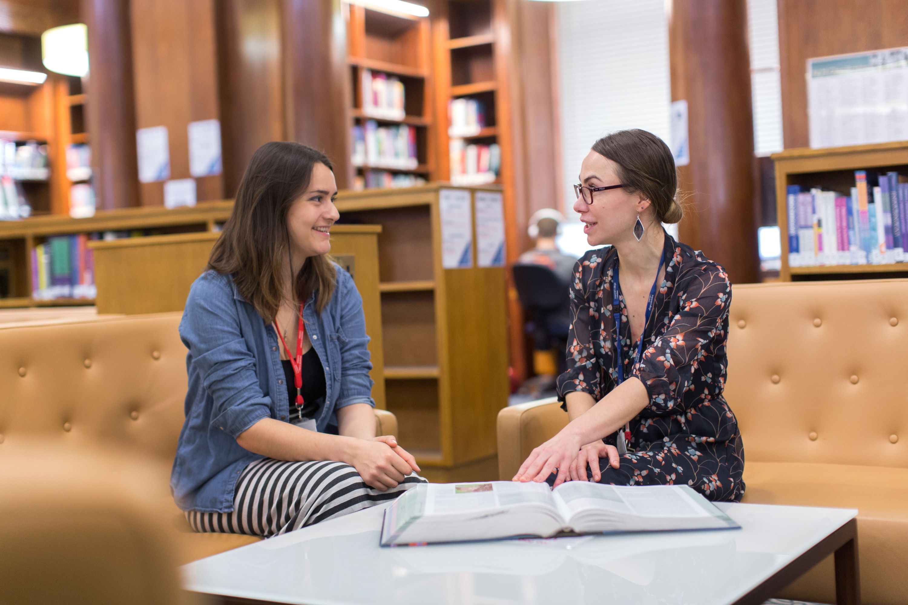 Two women sat in a library