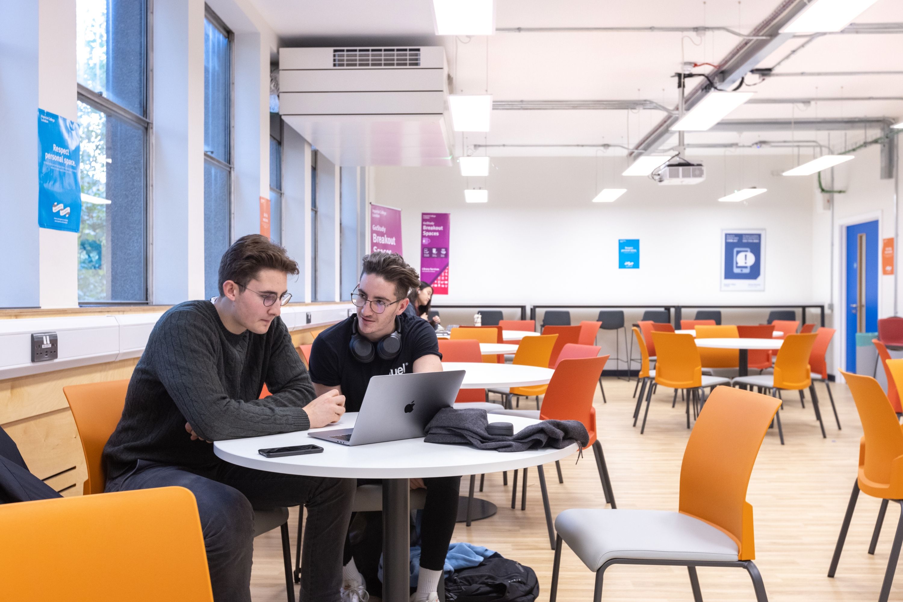 Two students sat in front of a laptop