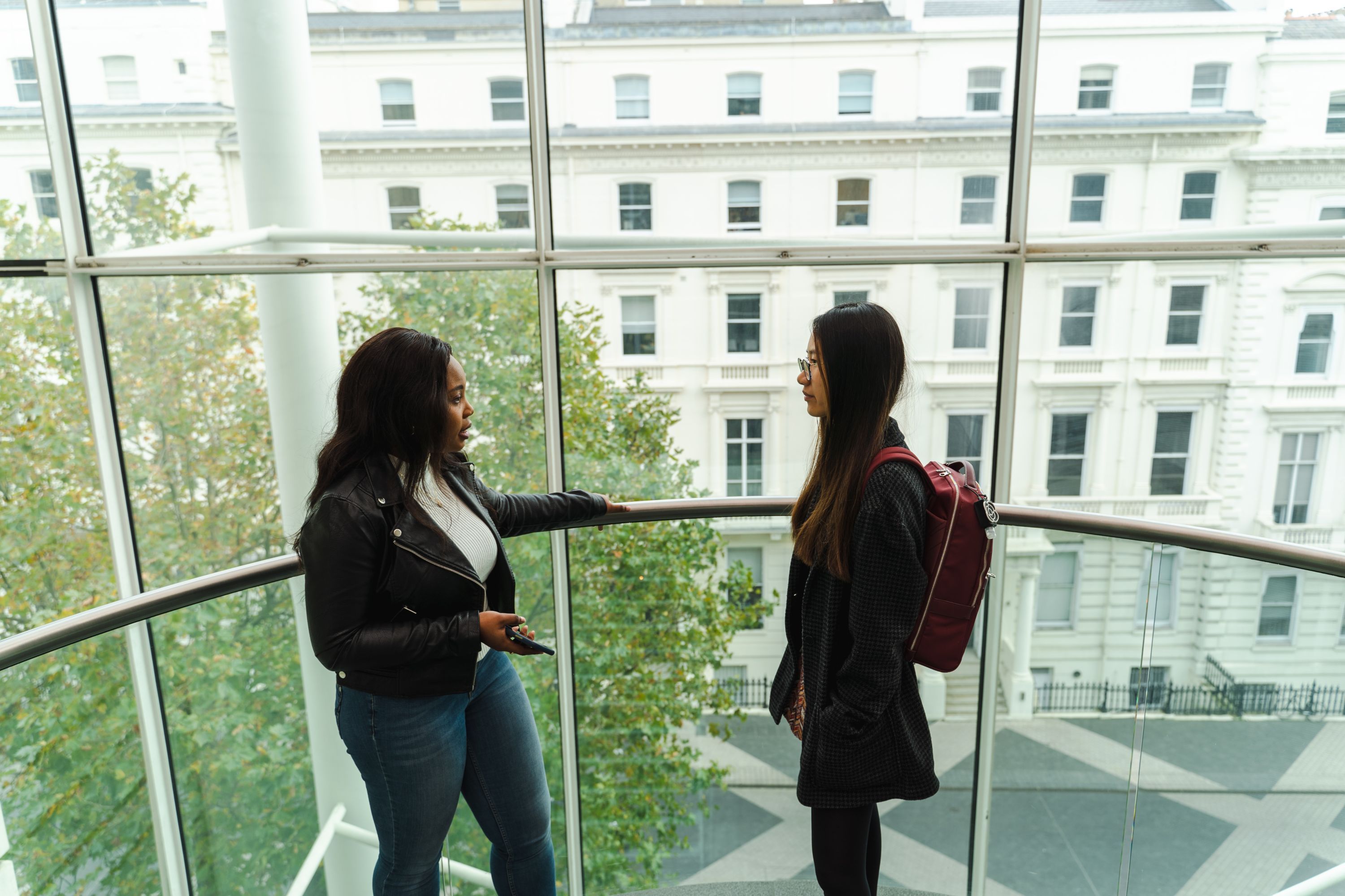 Finance students talking on a staircase in the business school