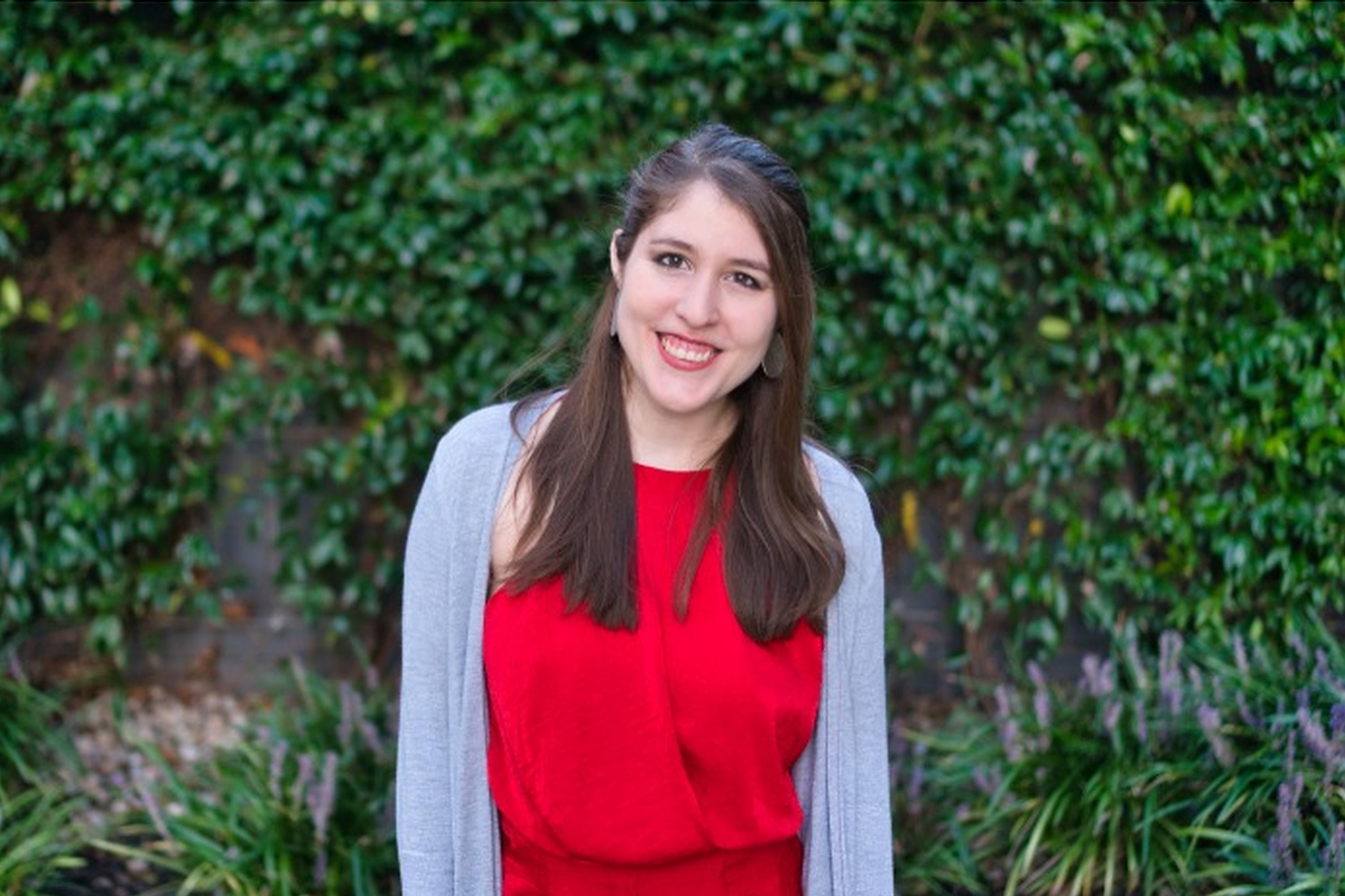 Javiera standing in front of vine covered wall