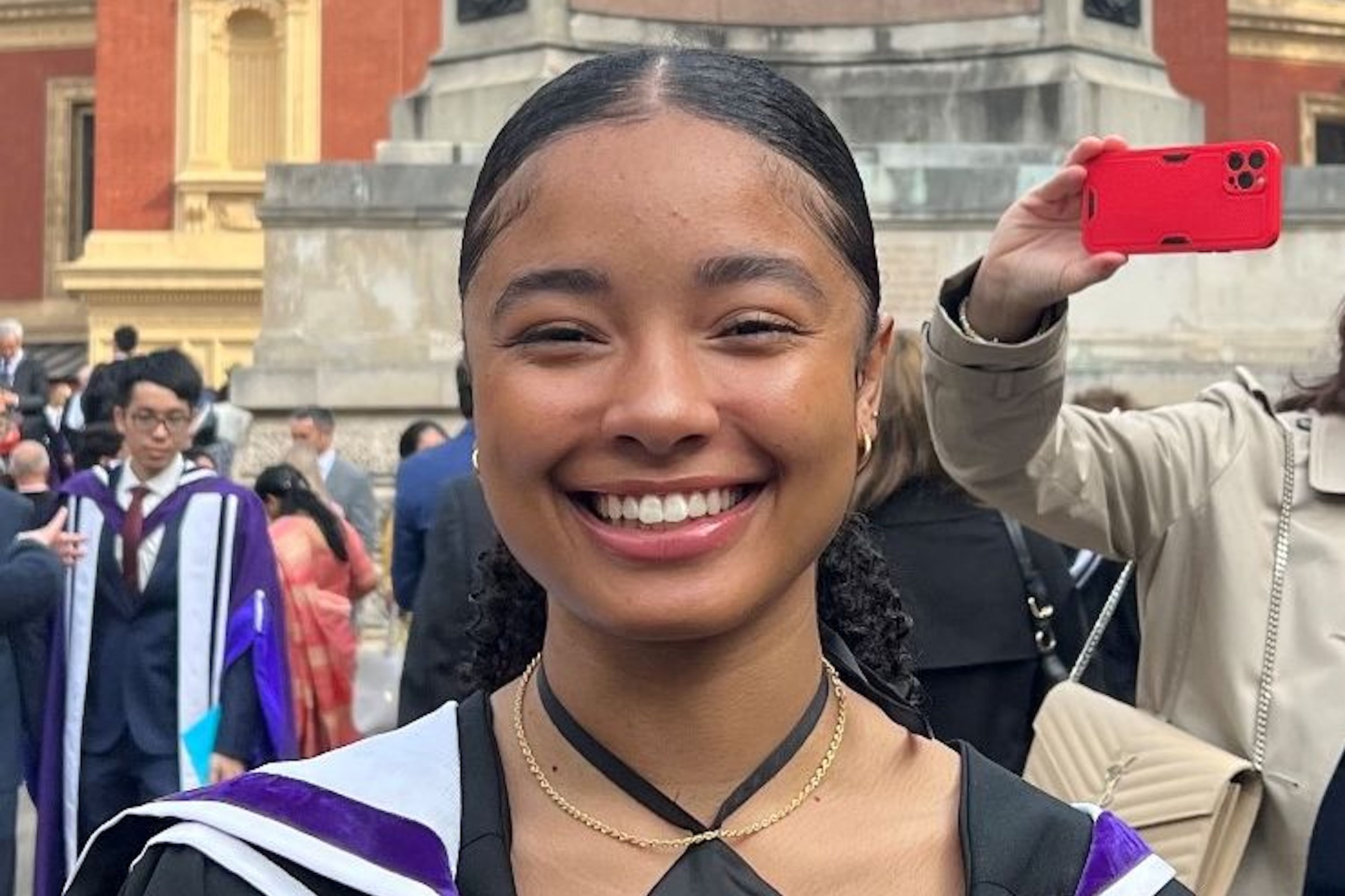 Jess in graduation gown in front of Royal Albert Hall