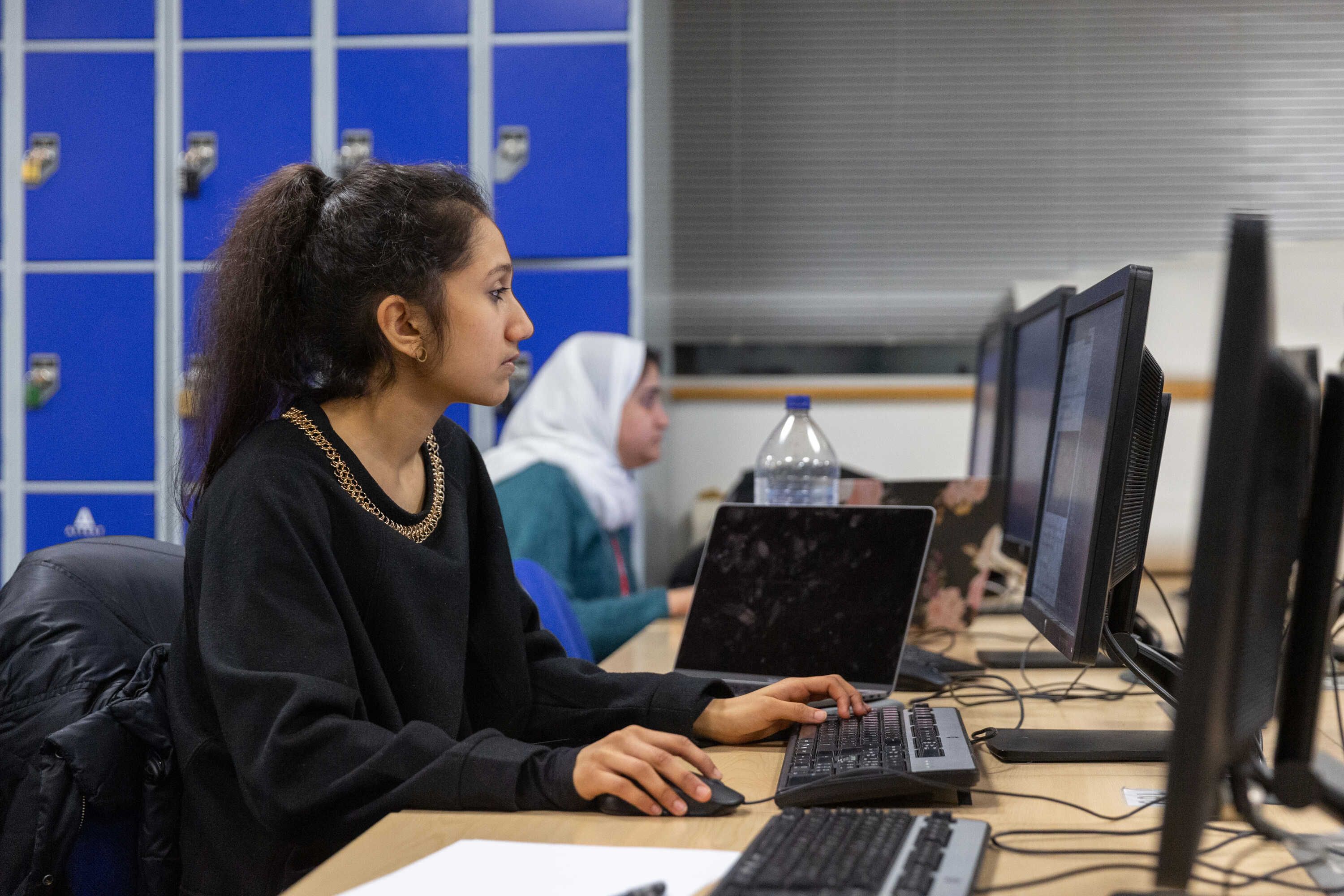 a female student working on a computer in a computer lab