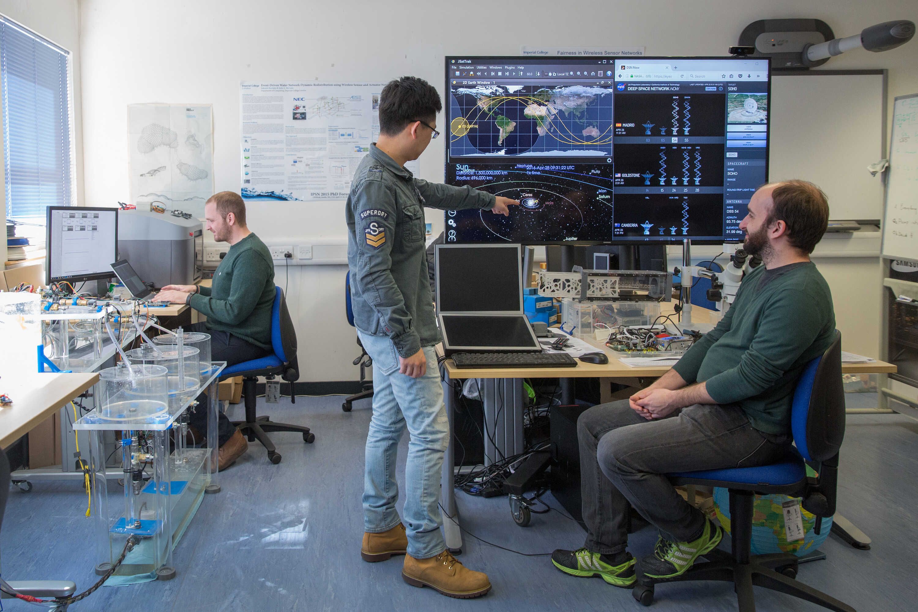 A student in a computer room pointing at a screen