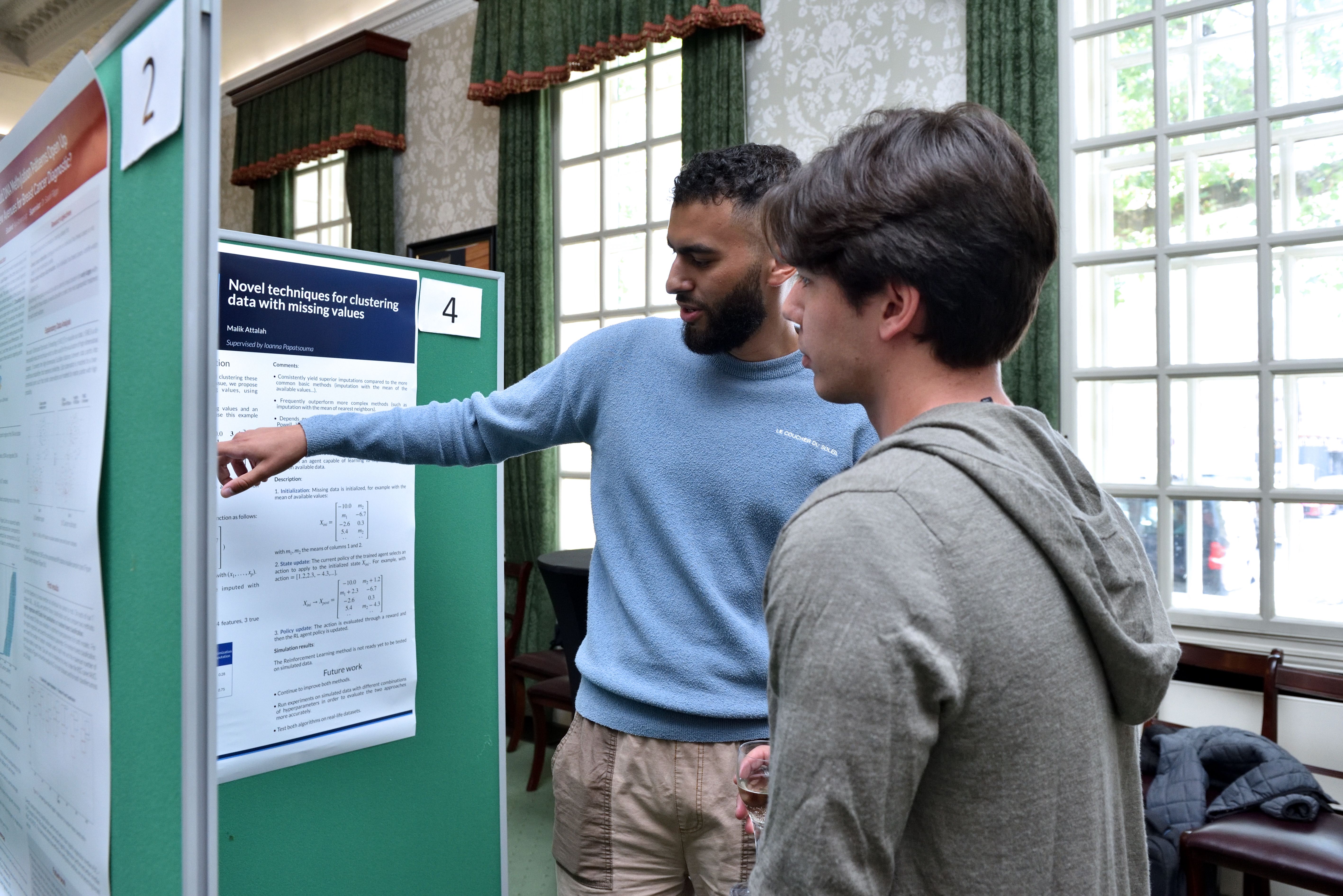 a male student showing a graph to another male student