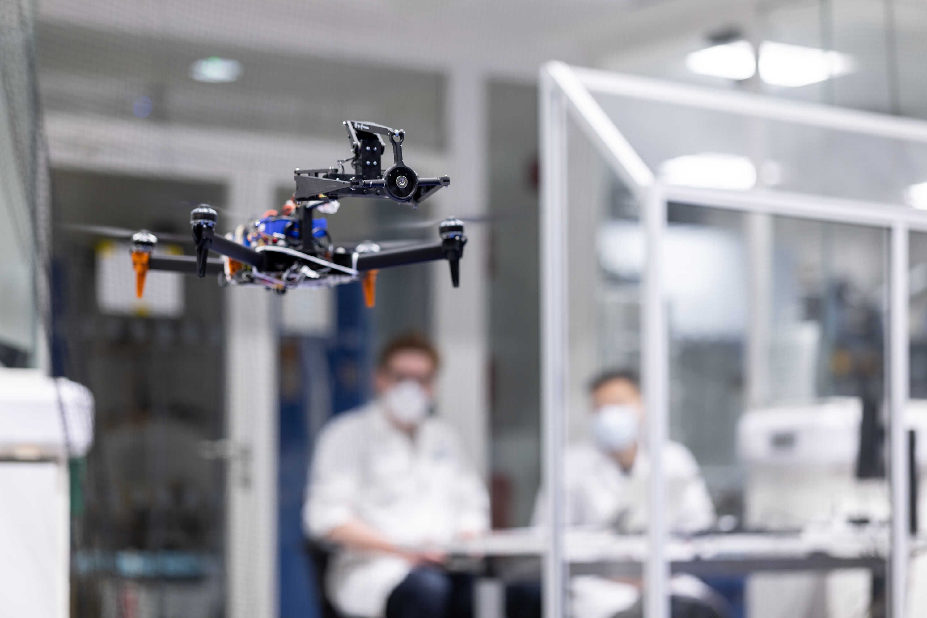 Two students flying a drone in the aerial robotics lab