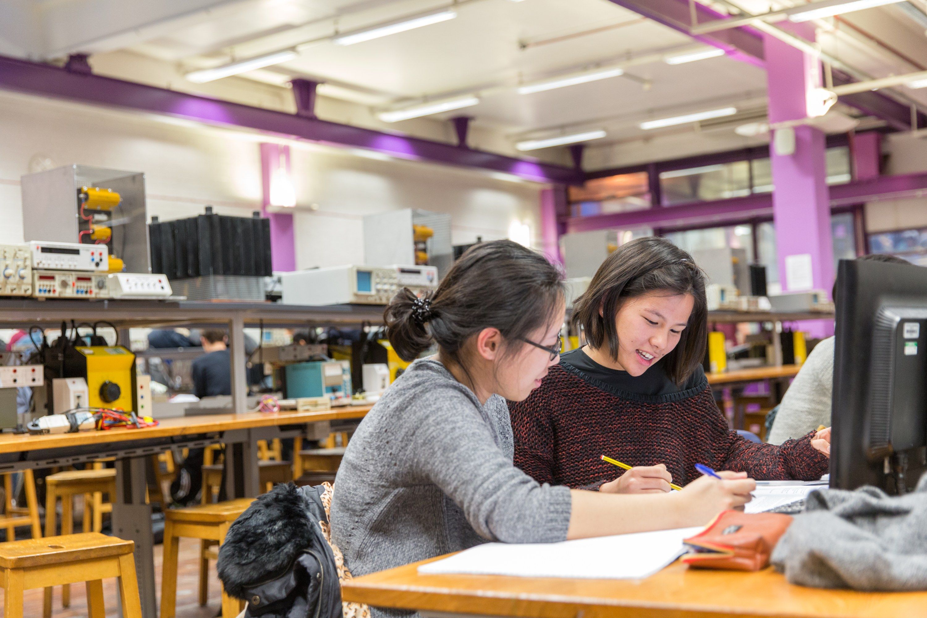 Two female students sat working at a desk