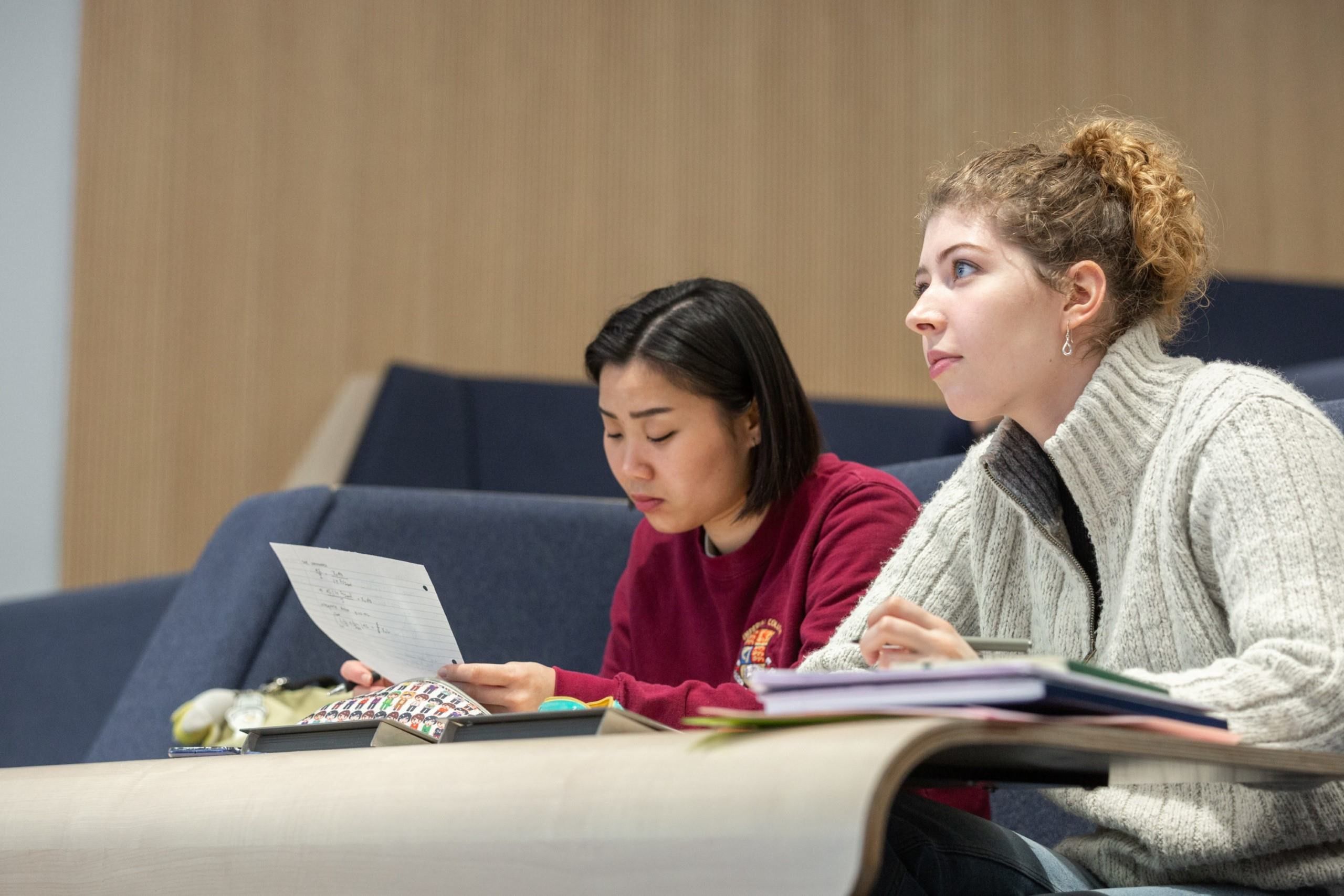 Two students in a lecture hall