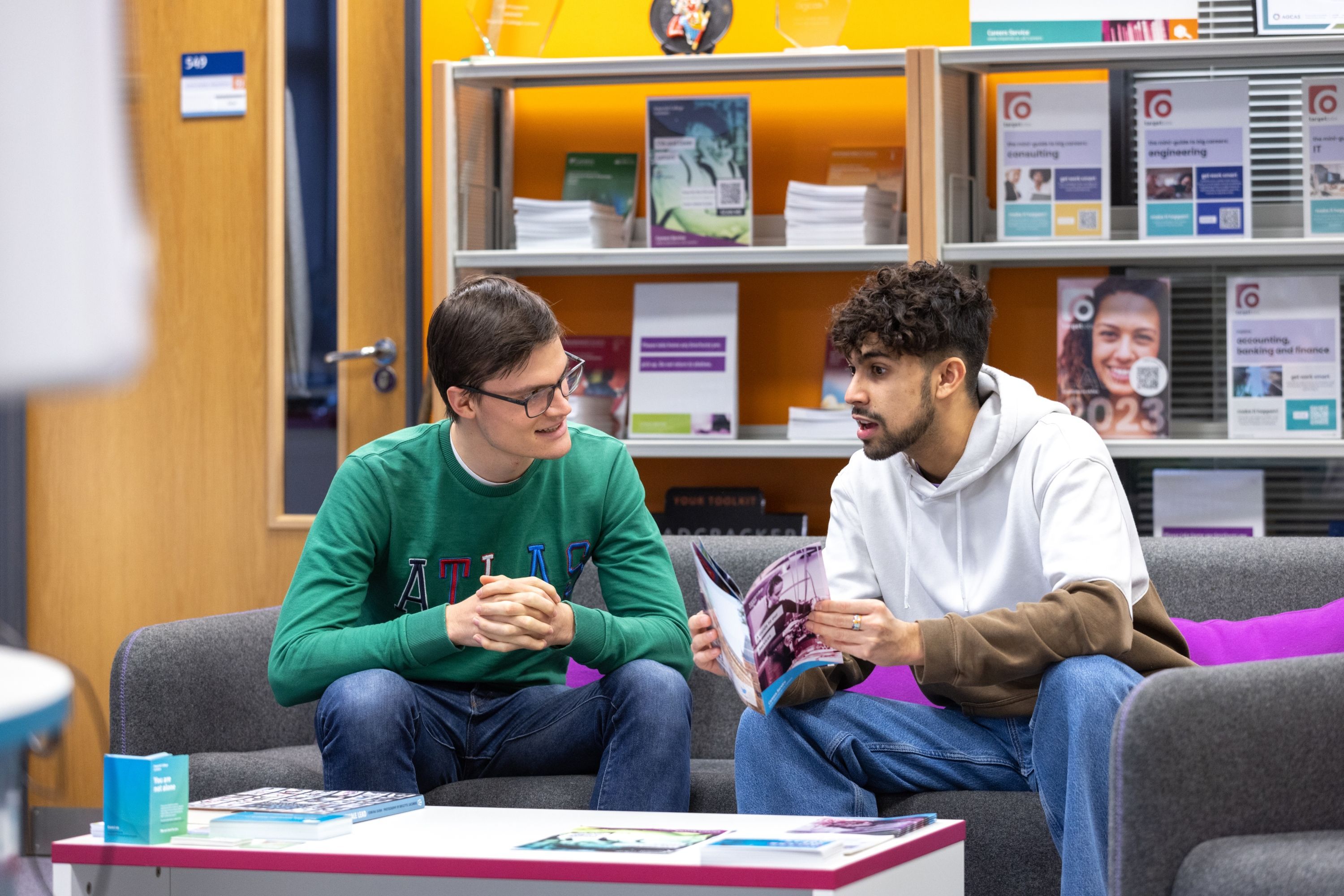 Two students chatting with leaflets