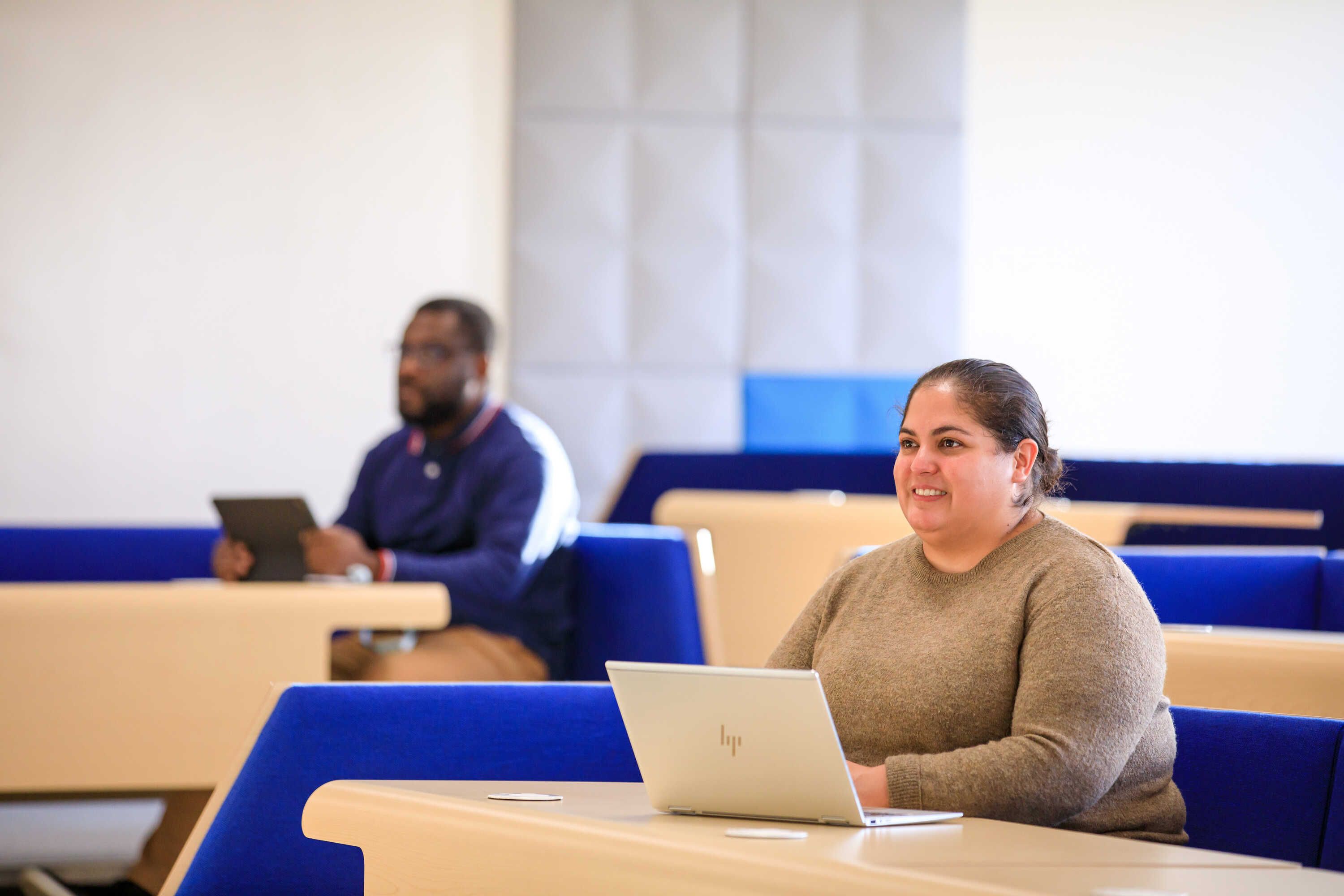 Two students sitting in a lecture hall at the Business School